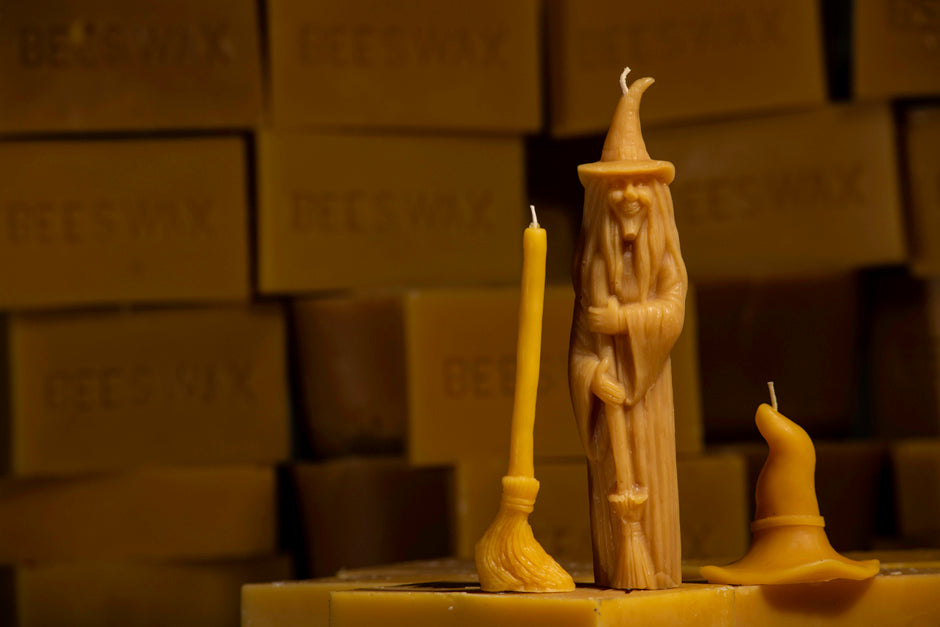 Witch, broom and witch hat shaped beeswax candles on beeswax bars