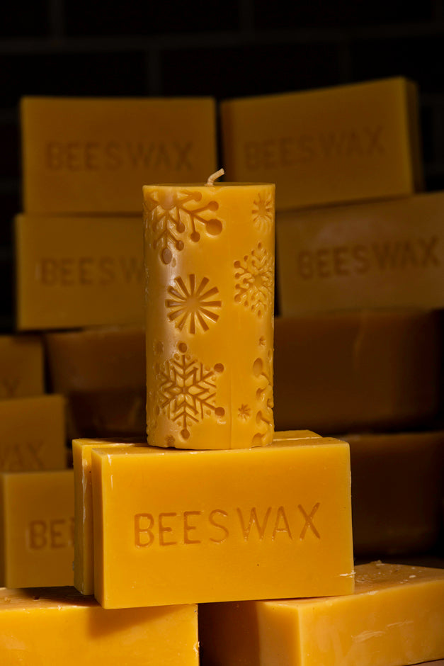 beeswax pillar candle with embossed snowflake designs on beeswax bars