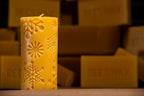 beeswax pillar candle with embossed snowflake designs on beeswax bars